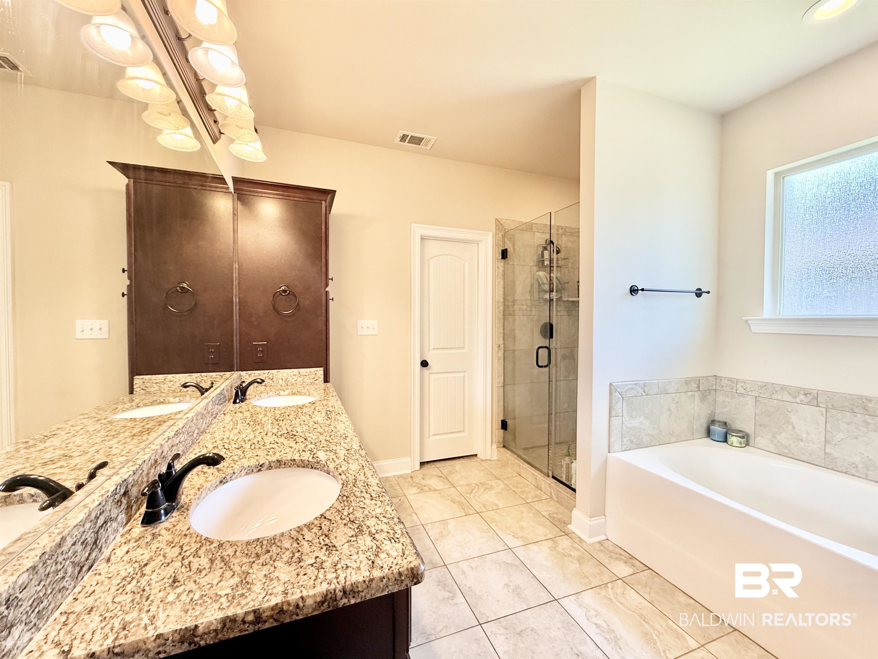 7011 Rocky Rd Loop Gulf Shores, AL 36542 - Photo 28 of 66 Bathroom with a bath, a stall shower, double vanity, and light tile patterned floors