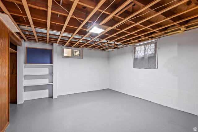 480 North 150 E Street Springville, UT 84663 - Photo 29 of 36 Unfinished basement featuring exposed wood ceiling joists, concrete block walls, and a painted concrete floor