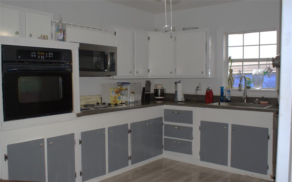 8660 County Road 308 Terrell, TX 75161 - Photo 6 of 18 a kitchen with stainless steel appliances a stove a sink and white cabinets