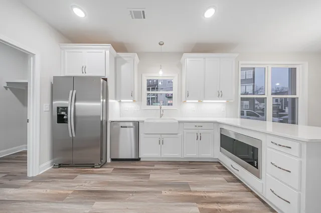 a kitchen with granite countertop a refrigerator oven and cabinets