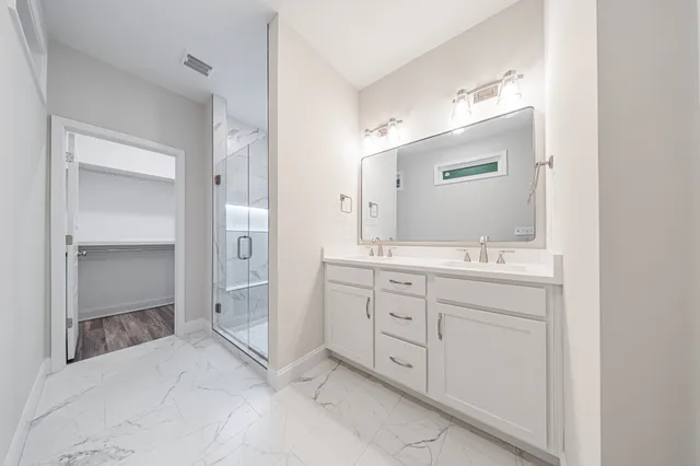 a spacious bathroom with a shower sink and mirror