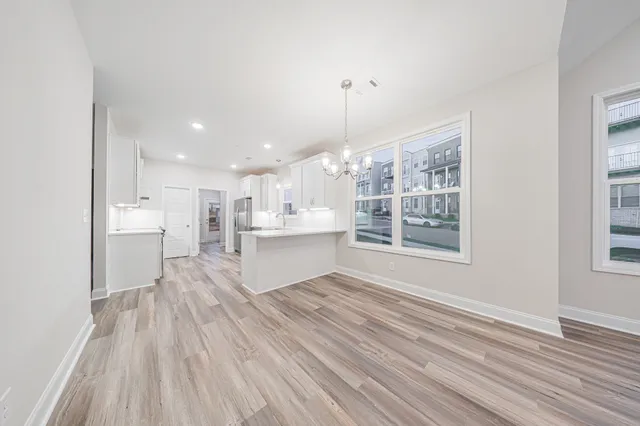 a open kitchen with kitchen island white cabinets and stainless steel appliances