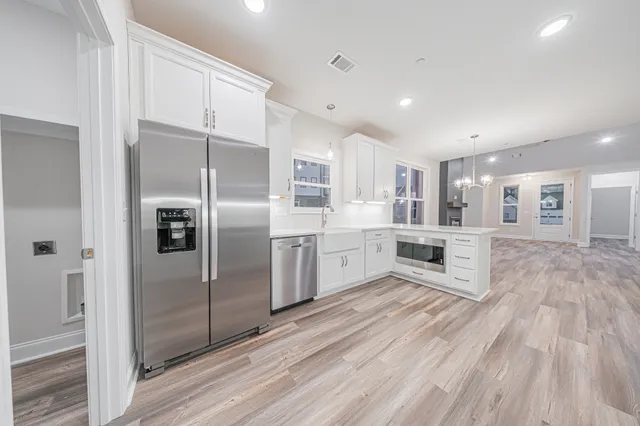 a kitchen with stainless steel appliances a refrigerator sink and cabinets