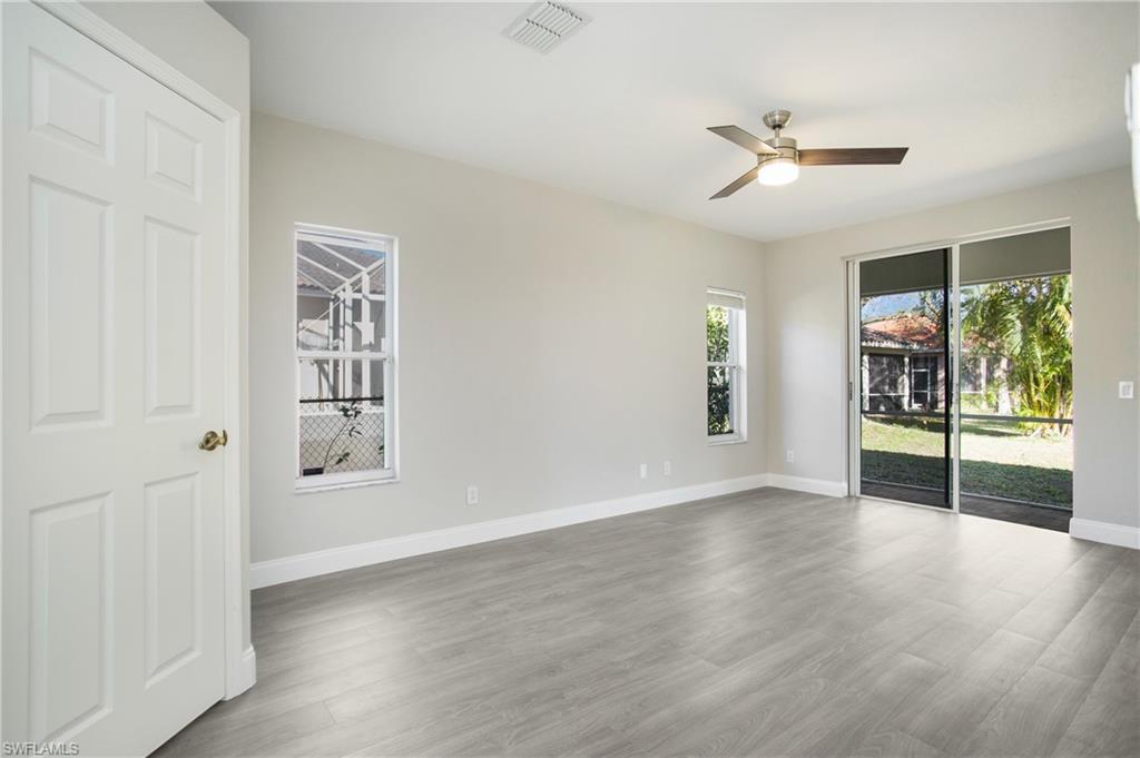 2921 Inlet Cove Lane East Naples, FL 34120 - Photo 16 of 48 an empty room with wooden floor fan and windows