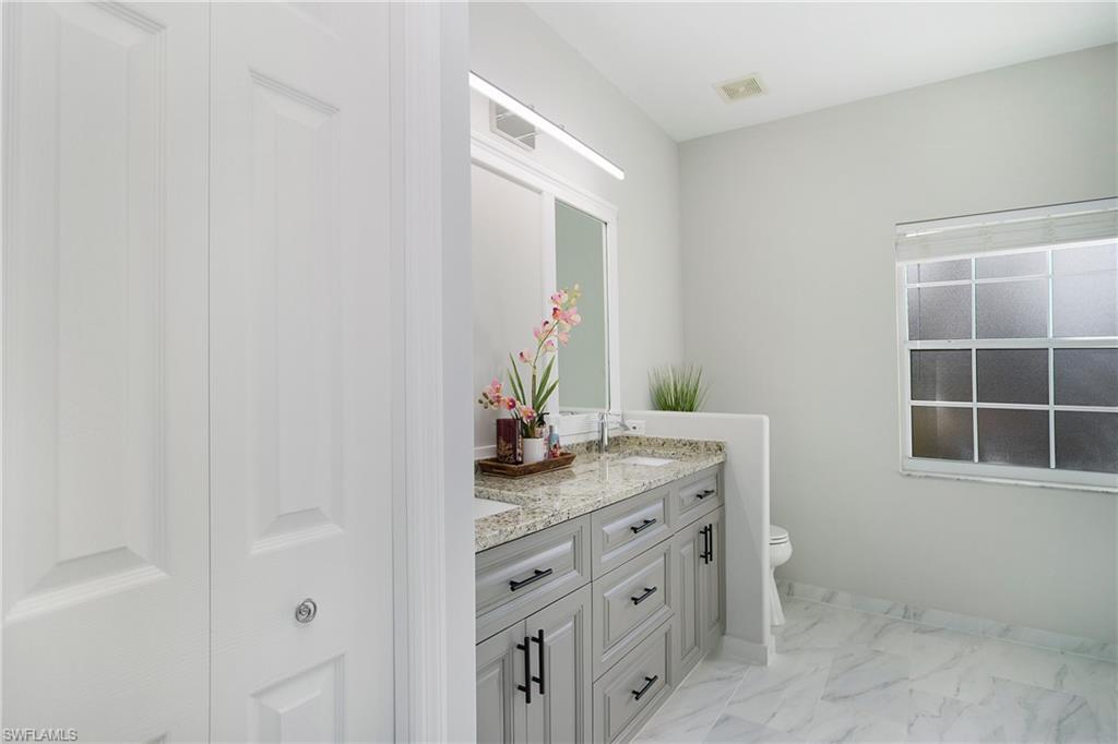 2921 Inlet Cove Lane East Naples, FL 34120 - Photo 19 of 48 a bathroom with a granite countertop sink and a mirror