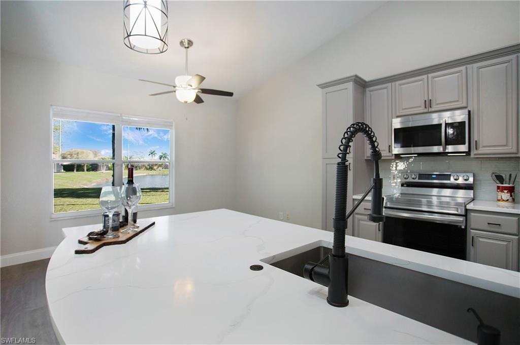 2921 Inlet Cove Lane East Naples, FL 34120 - Photo 2 of 48 a kitchen with stainless steel appliances a sink a microwave a refrigerator and cabinets