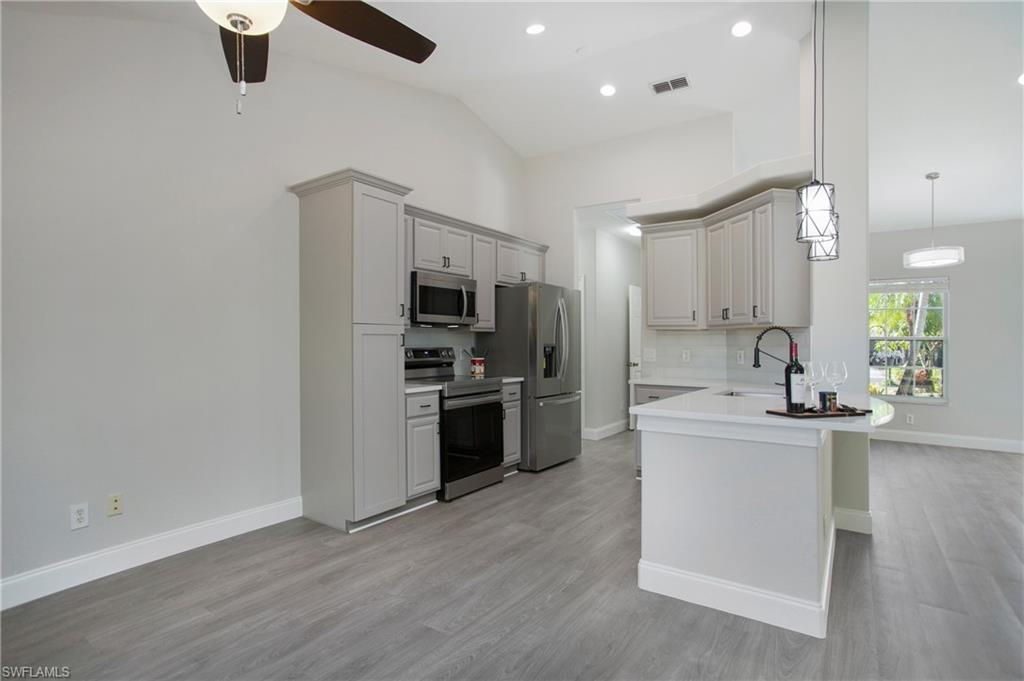 2921 Inlet Cove Lane East Naples, FL 34120 - Photo 5 of 48 a kitchen with stainless steel appliances a refrigerator and a stove top oven