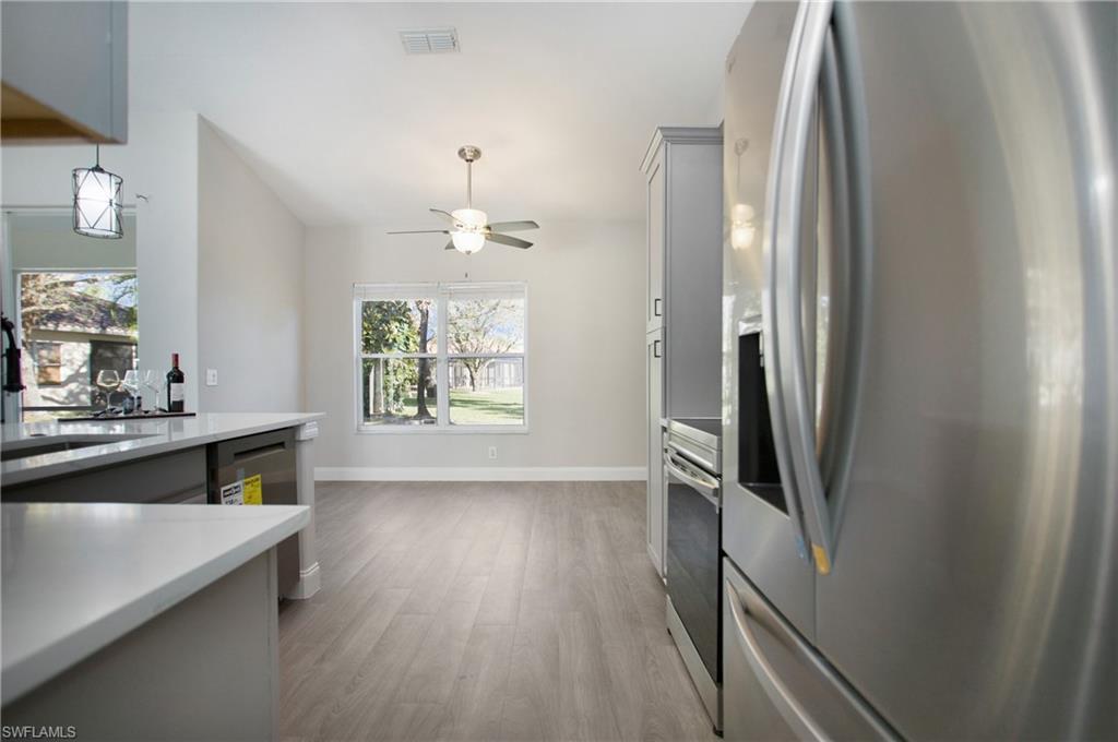 2921 Inlet Cove Lane East Naples, FL 34120 - Photo 8 of 48 a view of kitchen and hallway with wooden floor