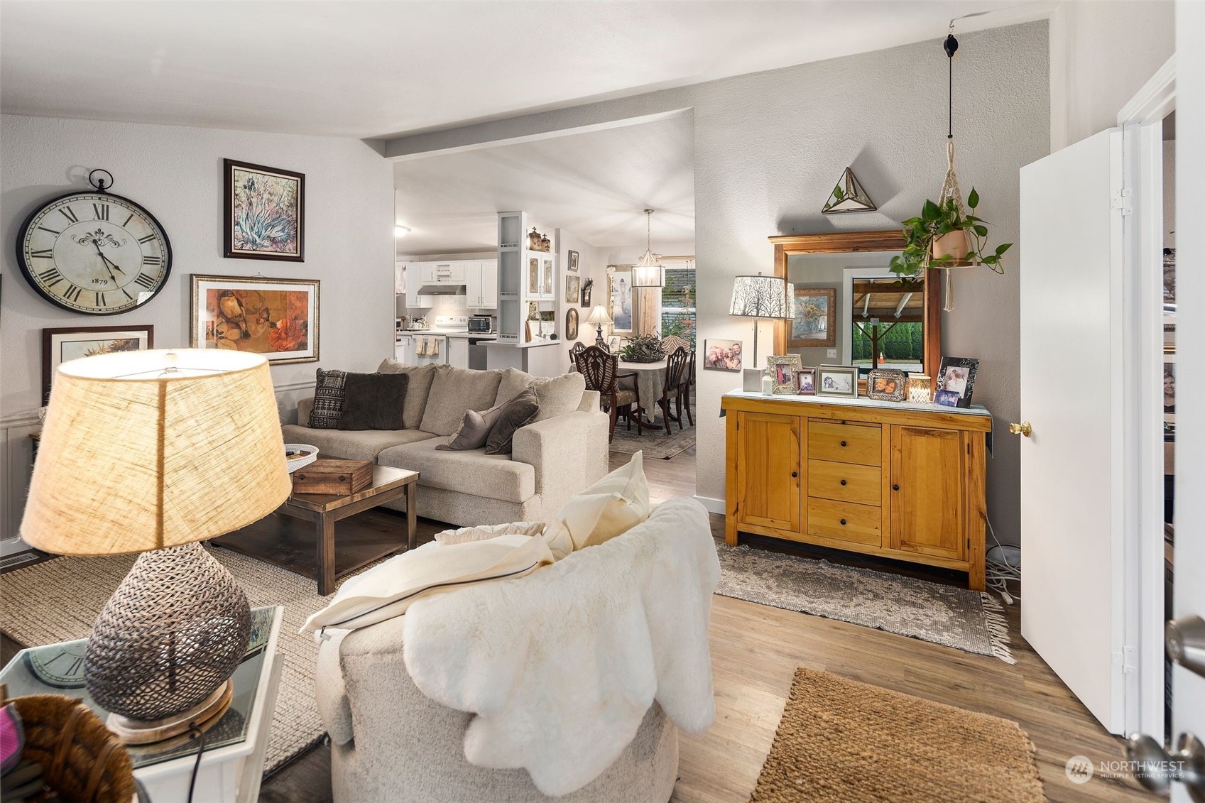 8730 206th Street Southeast, Unit 24 Snohomish, WA 98296 - Photo 4 of 33 a living room with furniture a clock and a view of kitchen