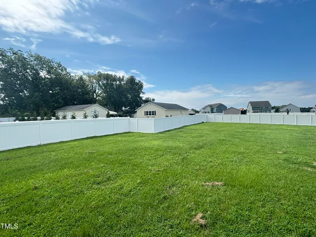 a backyard of a house with barbeque oven table and chairs