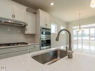 a kitchen with granite countertop a sink and cabinets