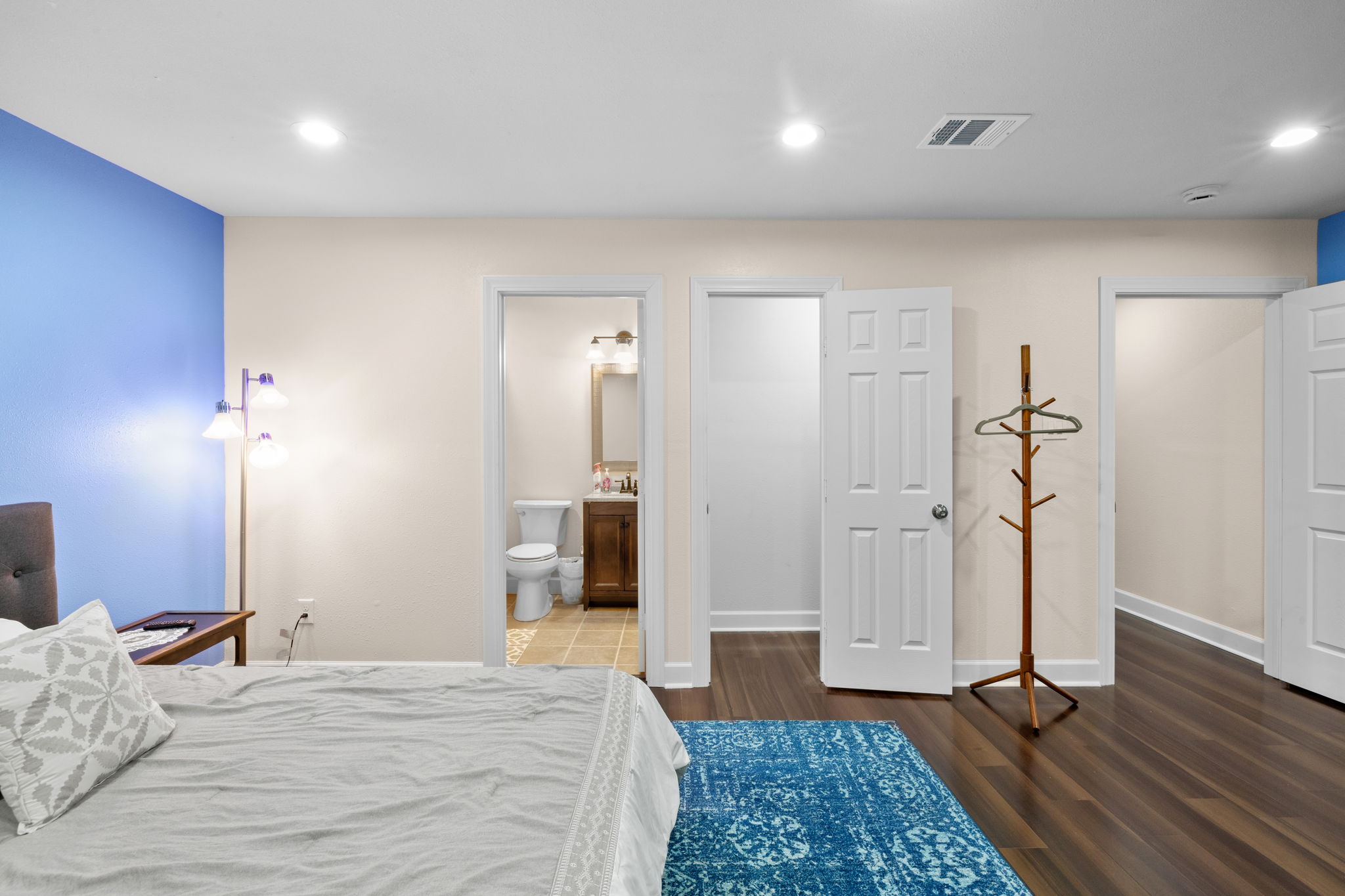 907 East 53rd Street Austin, TX 78751 - Photo 27 of 36 Hardwood flooring extends throughout this generous primary bedroom, offering seamless access to an adjoining bathroom.