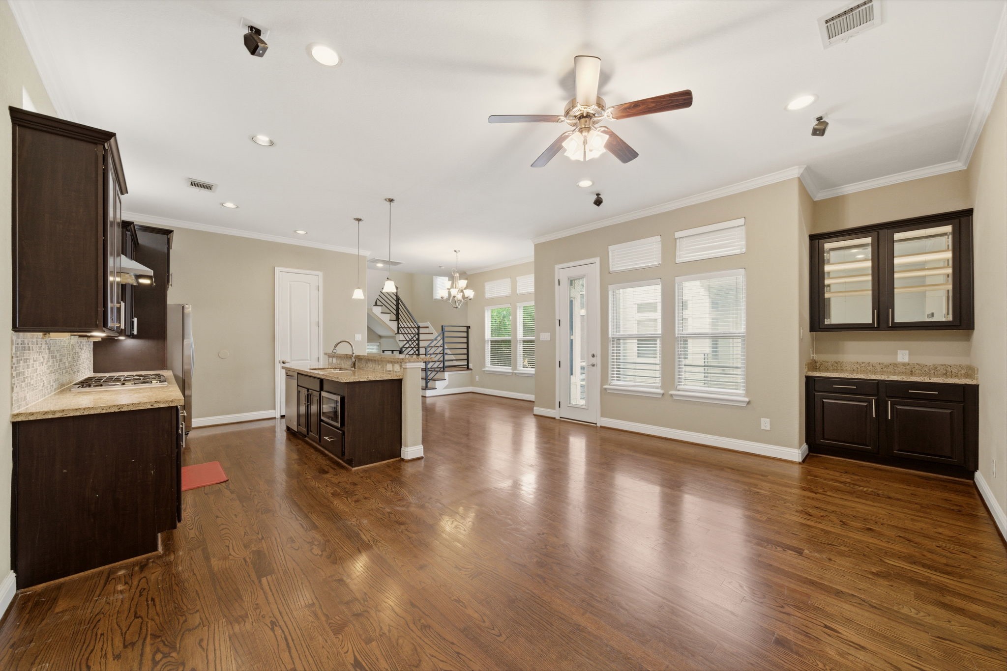 1113 West 18th Street, Unit A Houston, TX 77008 - Photo 5 of 21 a large kitchen with stainless steel appliances a large counter top a stove a sink dishwasher a refrigerator and a dining table with wooden floor