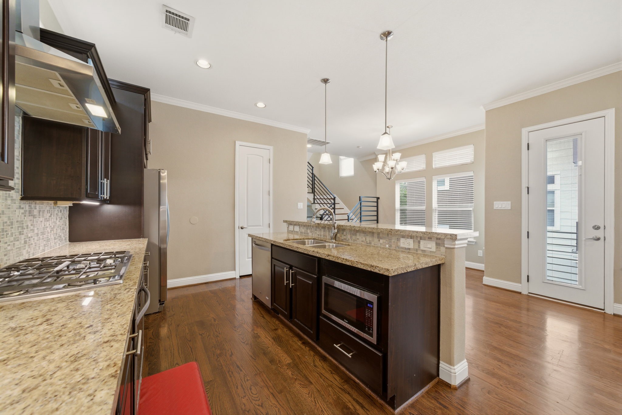 1113 West 18th Street, Unit A Houston, TX 77008 - Photo 9 of 21 a kitchen with stainless steel appliances granite countertop a stove a sink dishwasher a refrigerator and a dining table with wooden floor