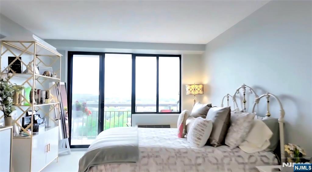 151 Prospect Avenue, Unit 16B Hackensack, NJ 07601 - Photo 12 of 25 a bedroom with a bed and a large window