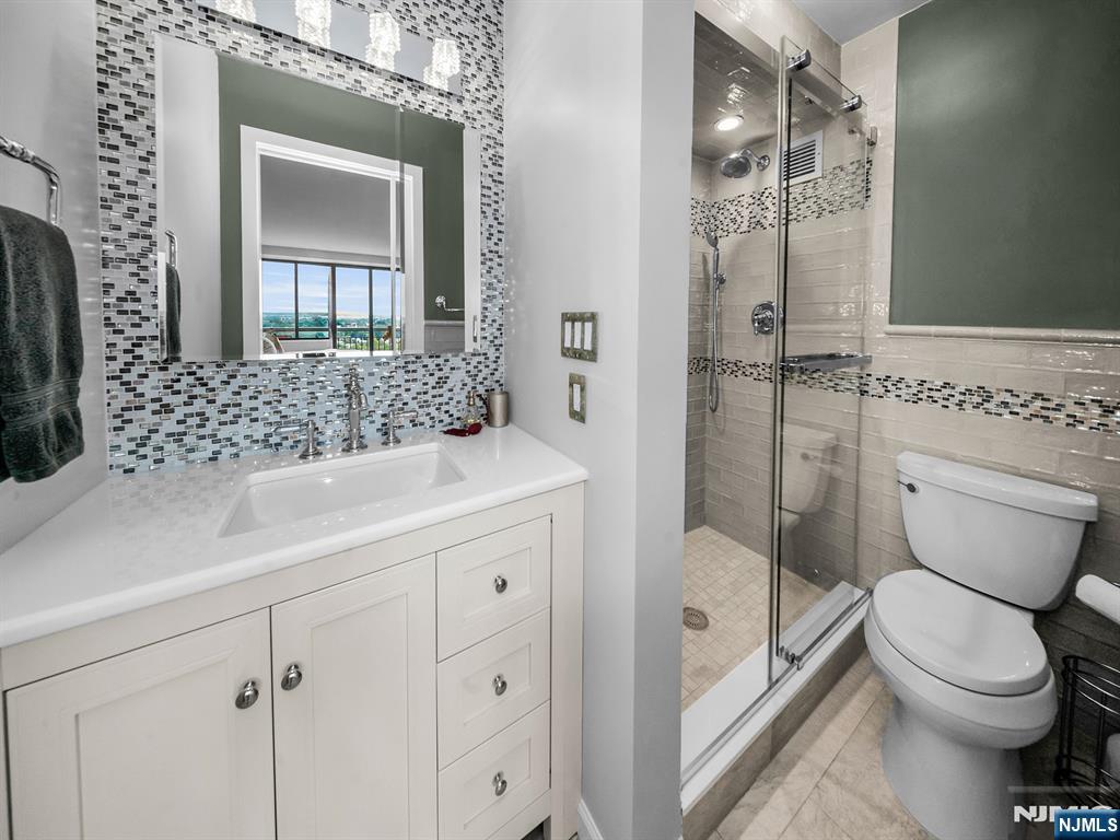 151 Prospect Avenue, Unit 16B Hackensack, NJ 07601 - Photo 14 of 25 a bathroom with a sink a toilet and shower