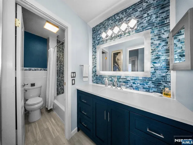 a bathroom with a toilet sink double vanity and mirror