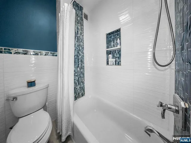 a white toilet sitting next to a bath tub