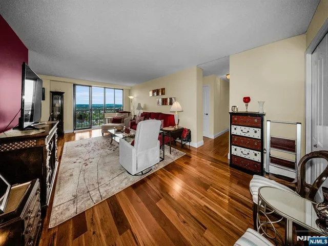 a living room with furniture a flat screen tv and a wooden floor