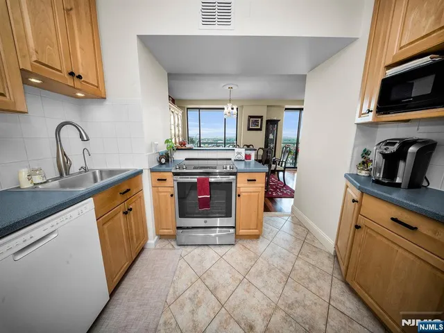 a kitchen with stainless steel appliances granite countertop a sink stove and cabinets