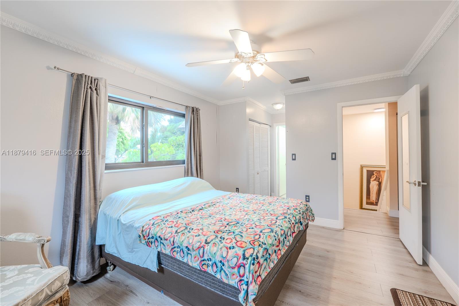6865 Northwest 169th Street, Unit D Hialeah, FL 33015 - Photo 13 of 21 a bedroom with a large bed and a chandelier