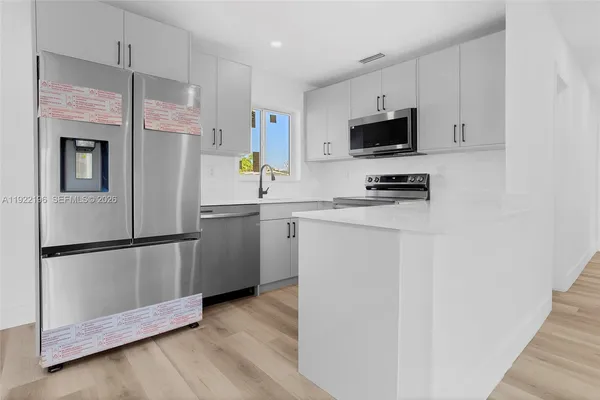 a kitchen with stainless steel appliances a refrigerator a stove a microwave and cabinets