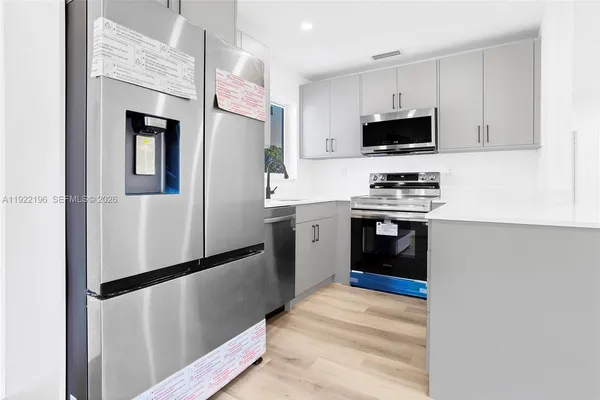 a kitchen with stainless steel appliances a refrigerator stove and microwave