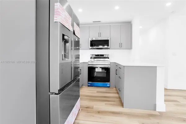 a kitchen with cabinets and stainless steel appliances