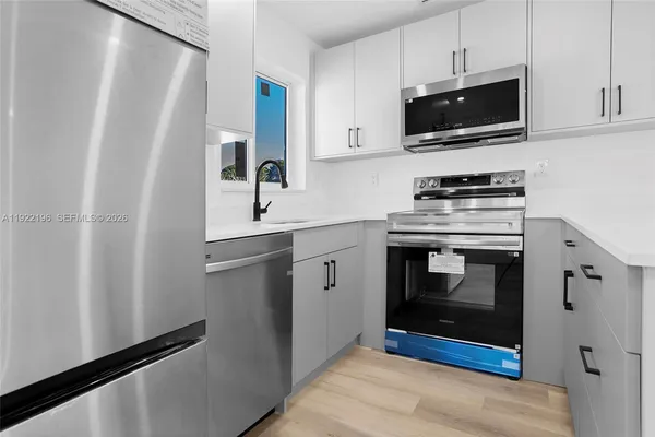 a kitchen with stainless steel appliances a stove microwave and refrigerator