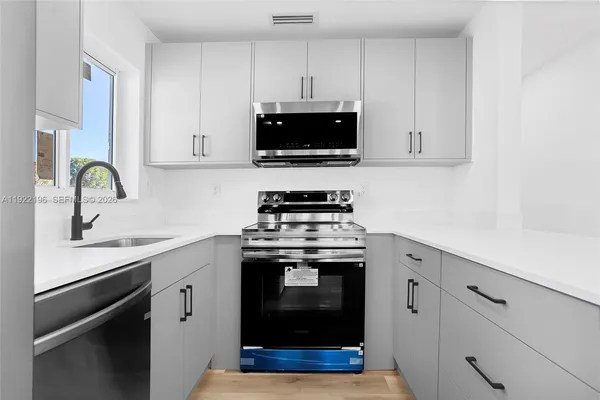 a kitchen with stainless steel appliances a stove a sink and a microwave