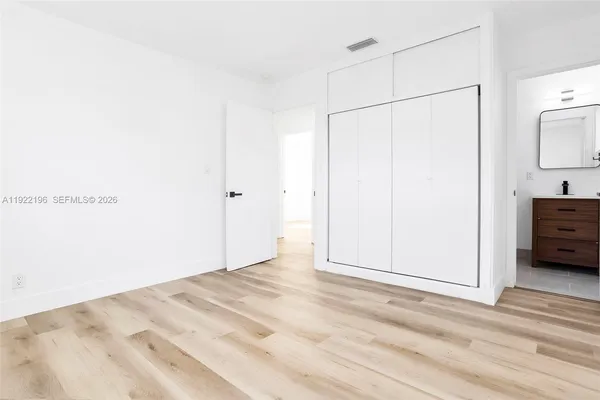 a view of empty room with wooden floor and cabinet