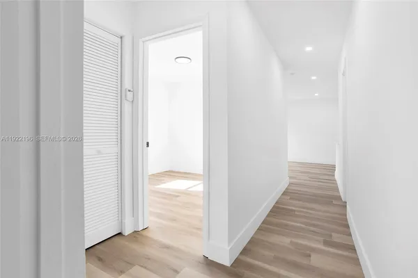 a view of a hallway with wooden floor and staircase