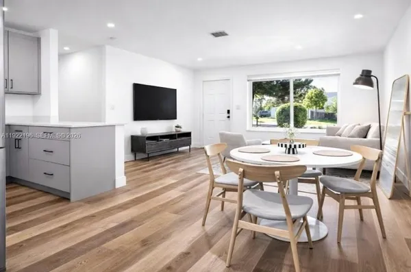 a view of a dining room with furniture and a flat screen tv