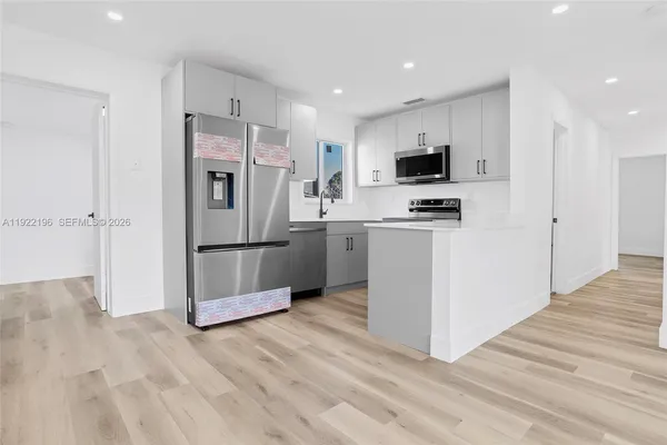 a kitchen with stainless steel appliances a refrigerator and a stove top oven