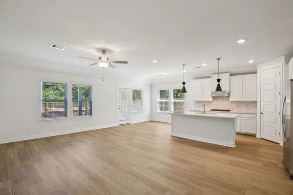a view of an empty room with kitchen appliances and a window