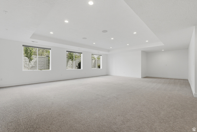 653 East Vandalay Lane Draper, UT 84020 - Photo 31 of 61 Spacious room featuring neutral carpeting, multiple windows, recessed lighting, a tray ceiling, and white painted walls