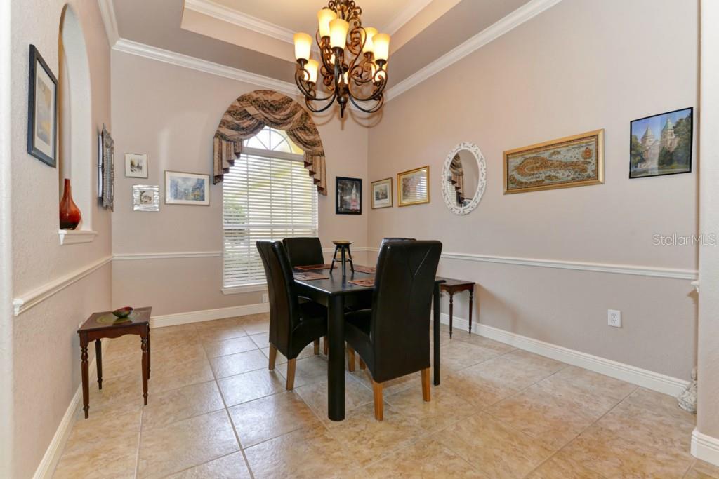 3302 Twin Rivers Trail Parrish, FL 34219 - Photo 7 of 24 Formal dining area with crown molding and chair rail, dynamic lighting, room for large table