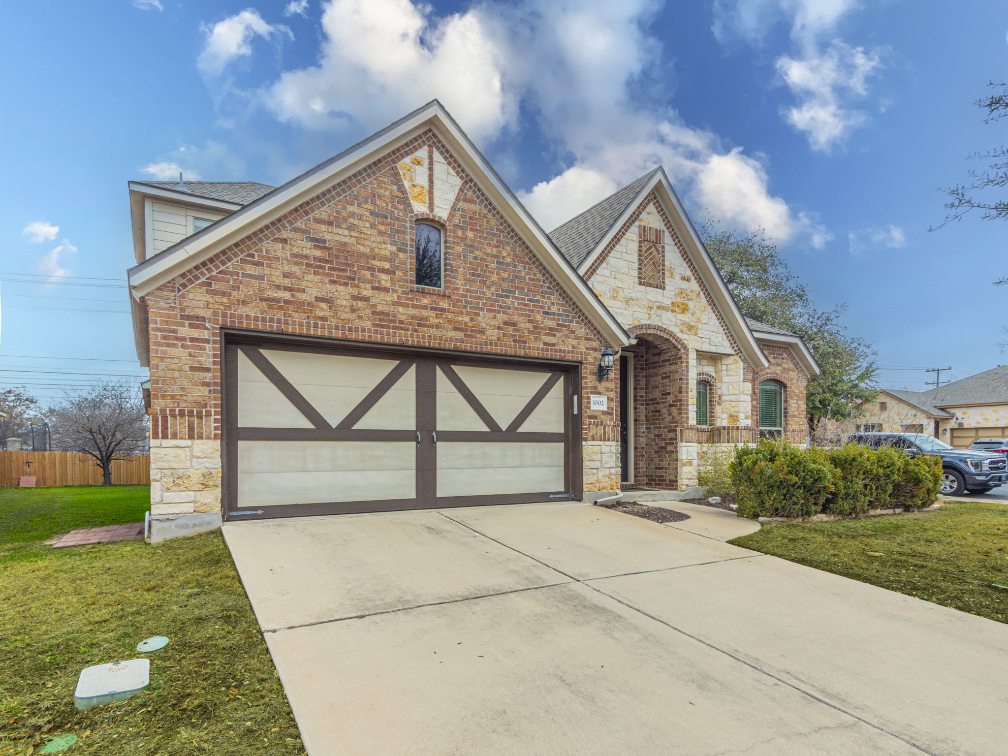1002 Boxwood Loop Georgetown, TX 78628 - Photo 3 of 25 View of front of house featuring stone siding, driveway, brick siding, a front lawn, and an attached garage