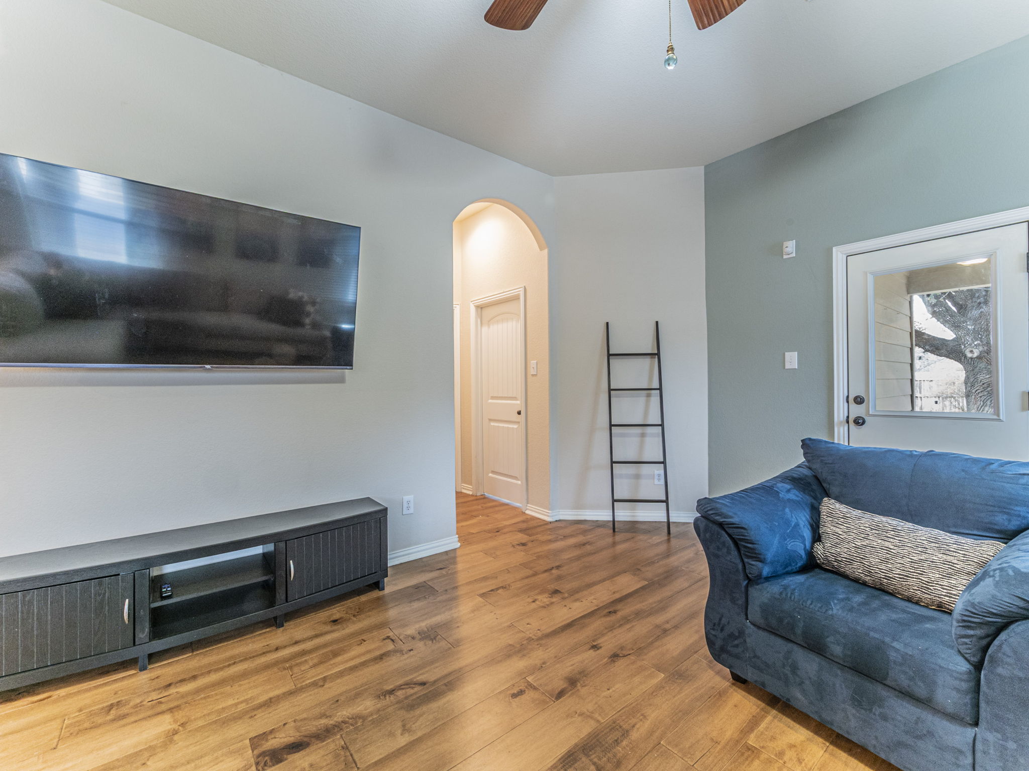 1002 Boxwood Loop Georgetown, TX 78628 - Photo 6 of 25 Living area with arched walkways, a ceiling fan, and light wood-style floors