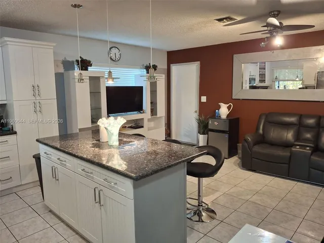 a kitchen with stainless steel appliances granite countertop a sink and a refrigerator