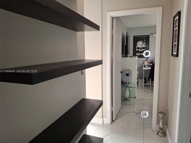 a view of a hallway and a room with wooden floor