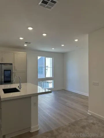 a view of kitchen with sink refrigerator and window