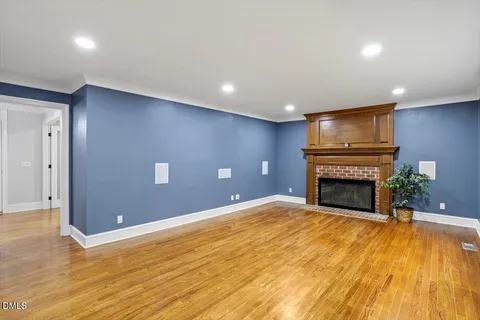 a view of empty room with a fireplace and wooden floor