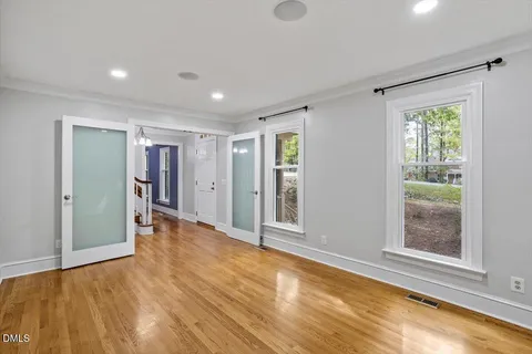 a view of empty room with wooden floor