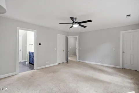 an empty room with a window and a fan