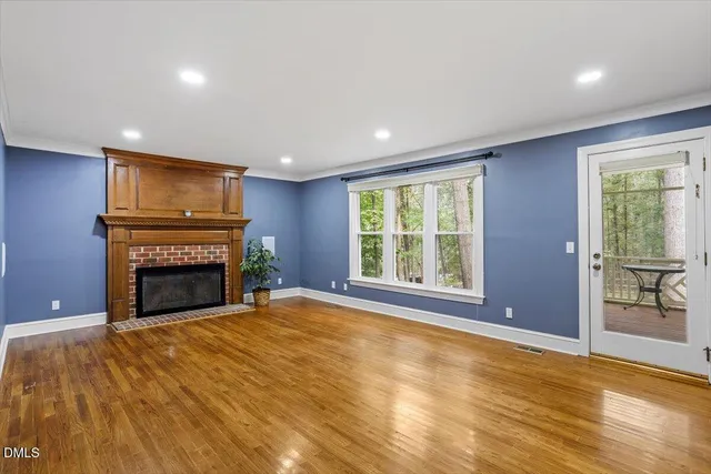 a view of an empty room with a fireplace and a window