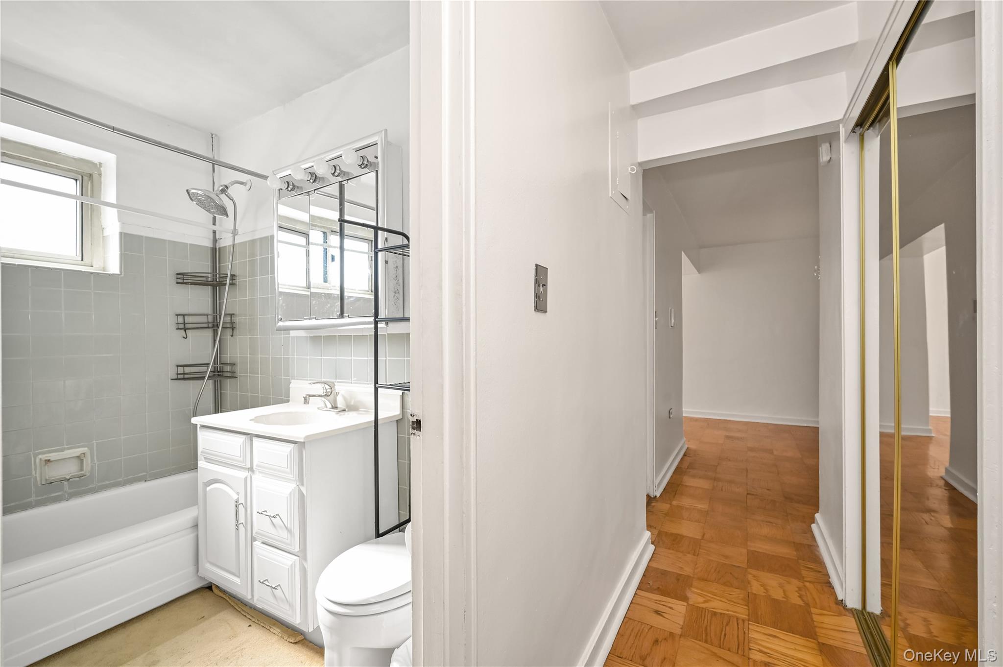 99-10 60th Avenue, Unit 1E Queens, NY 11368 - Photo 16 of 18 a bathroom with a sink a toilet and shower