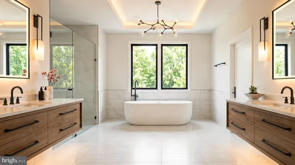 a en suite bathroom with a double vanity sink a large mirror and a bathtub