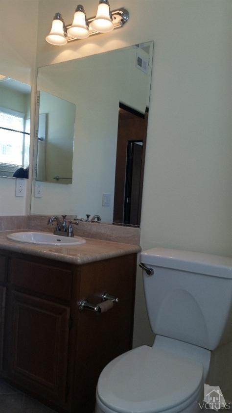 1430 Windshore Way Oxnard, CA 93035 - Photo 16 of 55 a bathroom with a granite countertop toilet sink and mirror