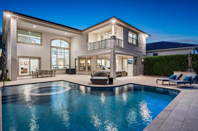 a view of a house with swimming pool and sitting area